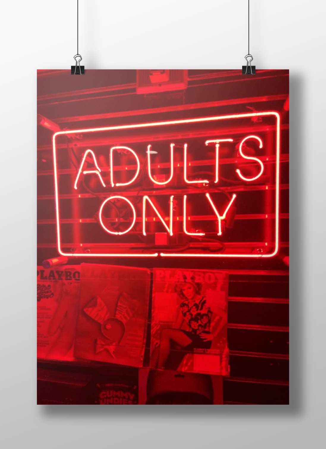 Red neon sign reading "ADULTS ONLY" mounted above PlayboY magazine covers Red Neon Adults Only