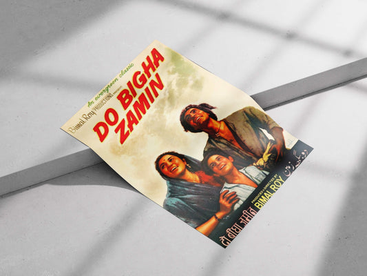 Vintage movie poster for 'Do Bigha Zamin' with two people on a gray . Vintage Do Bigha Zamin movie poster featuring a family looking at a bright sky, styled in a sunlit modern home office. surface