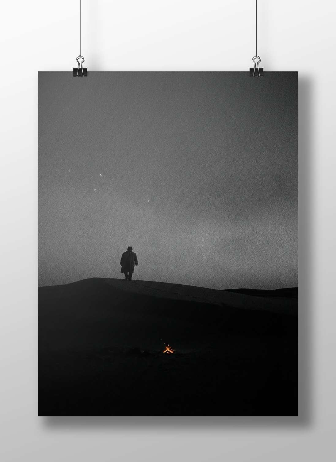 A lone human silhouette standing atop a sand dune under a starry night sky Main Subject: A lone human silhouette standing