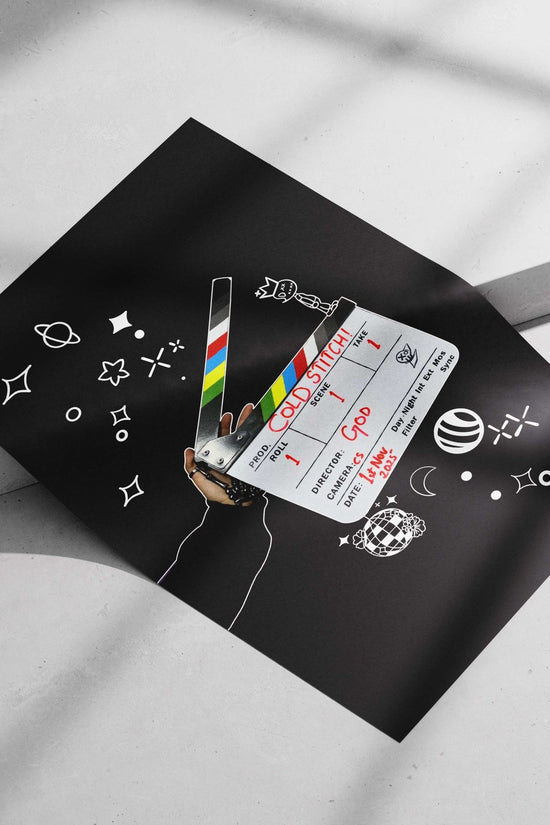 Clapperboard displaying "COLD STITCH!" project name and "Ggod" (deity) as director. Main Subject: Clapperboard displaying