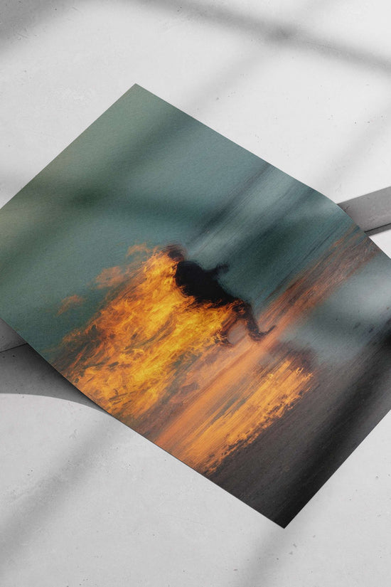 Silhouetted figure running on a beach with fiery flames engulfing its back Silhouetted Runner Beach
