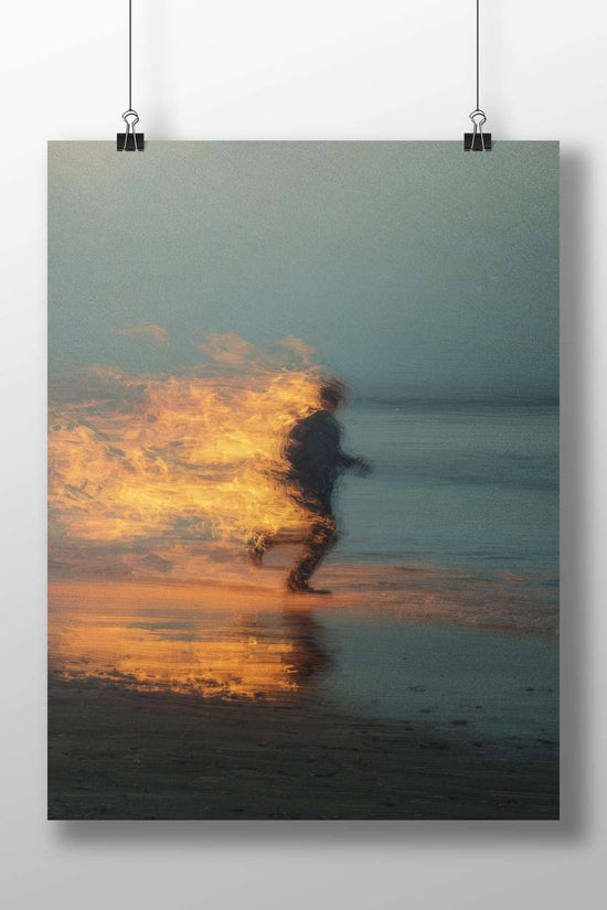 Silhouetted figure running on a beach with fiery flames engulfing its back Silhouetted Runner Beach