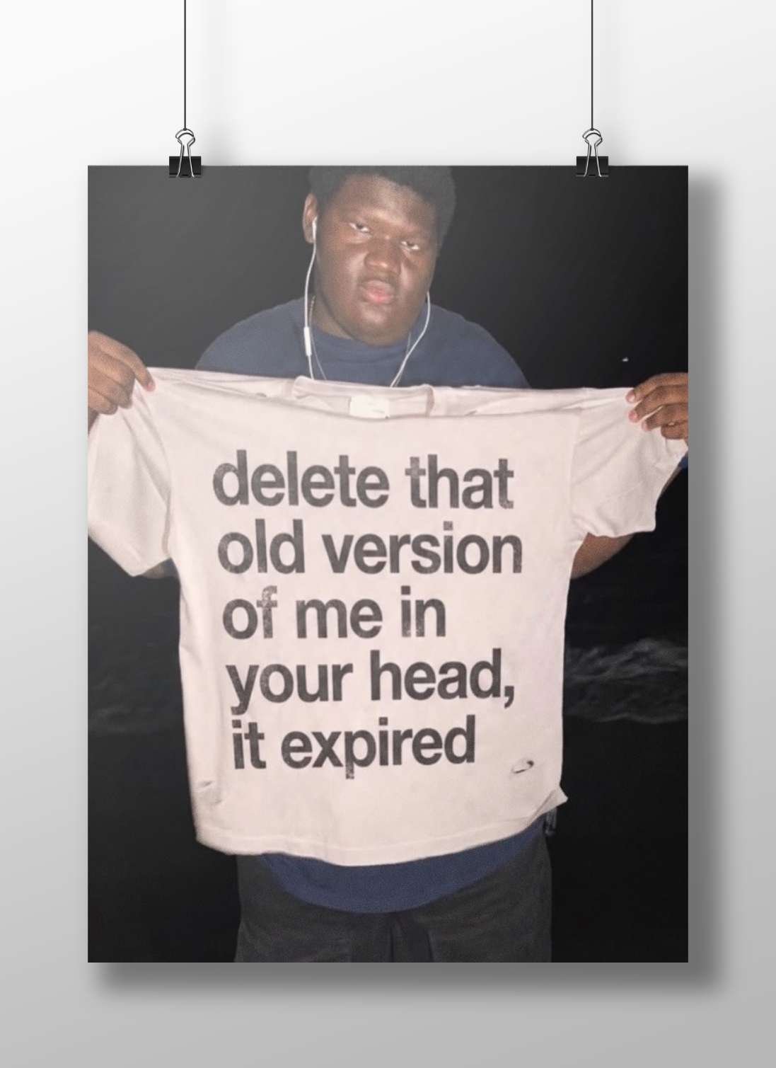 The phrase "delete that old version of me in your head, it expired" printed on a T-shirt. Main Subject: The phrase "delete
