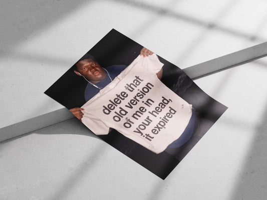 The phrase "delete that old version of me in your head, it expired" printed on a T-shirt. Main Subject: The phrase "delete