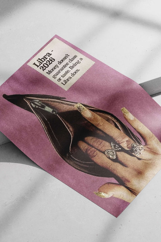 A human hand with gold glitter nail polish and bow-shaped rings positioned inside an open black stiletto heel, accompanied