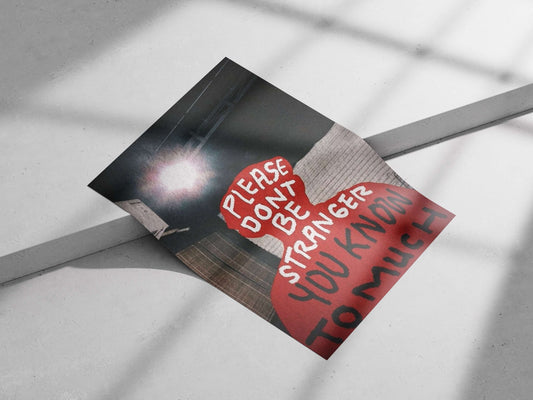 The phrase "PLEASE DON'T BE STRANGER YOU KNOW TO MUCH" displayed in a red silhouette. Main Subject: The phrase "PLEASE DON'T